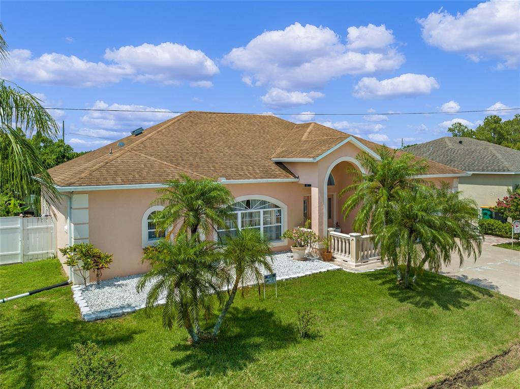 A single-story peach-colored house with a brown shingled roof and two palm trees in front — 323 ALEGRIANO COURT, KISSIMMEE, FL