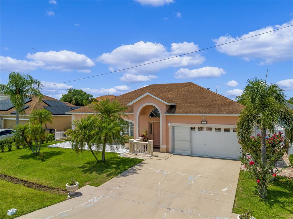 A single-story peach-colored house with a brown roof, arched entryway, and a concrete driveway — 323 ALEGRIANO COURT, KISSIMMEE, FL