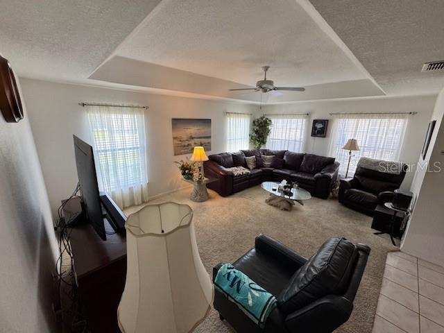 A living room features a large sectional sofa, a recliner, and a tray ceiling — 11299 SW 71ST TERRACE ROAD, OCALA, FL