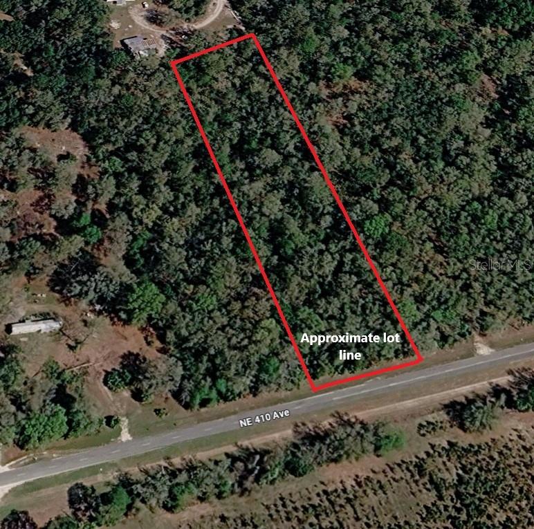 An aerial view shows a rectangular, wooded plot of land bordering a paved road — 000 NE 410TH AVENUE, OLD TOWN, FL