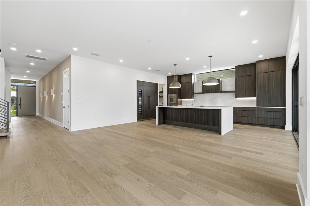 A modern kitchen with dark wood cabinetry and a large island sits in an open-concept room — 2517 RIVERSIDE DR, TAMPA, FL