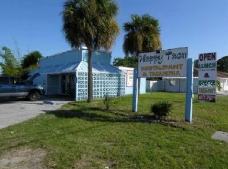 A blue restaurant building with a sign stands next to a parked truck on grass — 202 N FISKE BOULEVARD UNIT 202-204, COCOA, FL