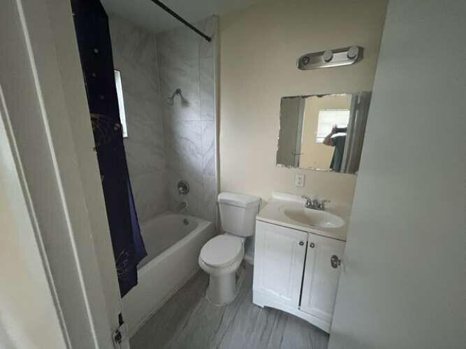 A bathroom featuring a white vanity, a toilet, and a bathtub with a shower head — 3370 NW 8th Place, Lauderhill FL 33311, LAUDERHILL, FL
