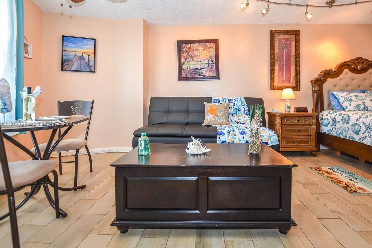 A studio room features a dining set, a black sofa, and a bed with coastal decor — 313 S. ATLANTIC AVE # 217, Daytona FL 32118, DAYTONA, FL