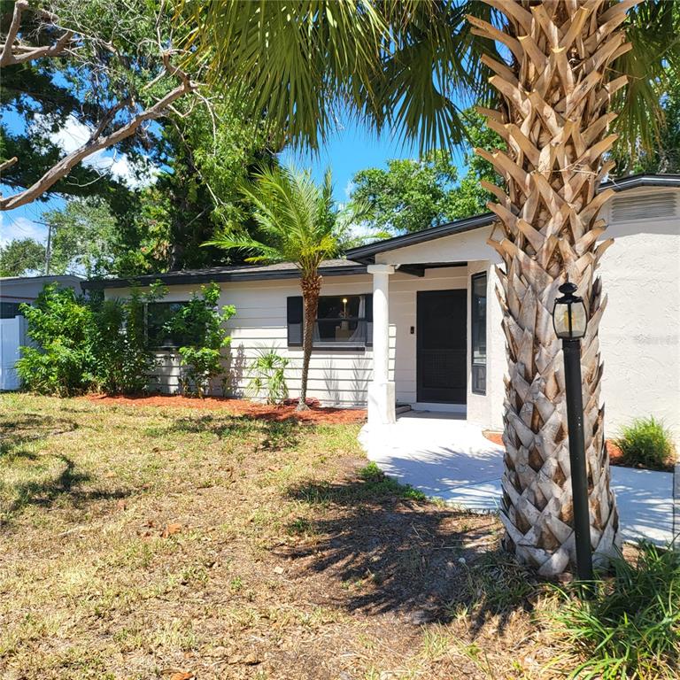 A single-story house with light-colored siding, a front porch, and a prominent palm tree — 5107 CRESTHILL DRIVE, TAMPA, FL