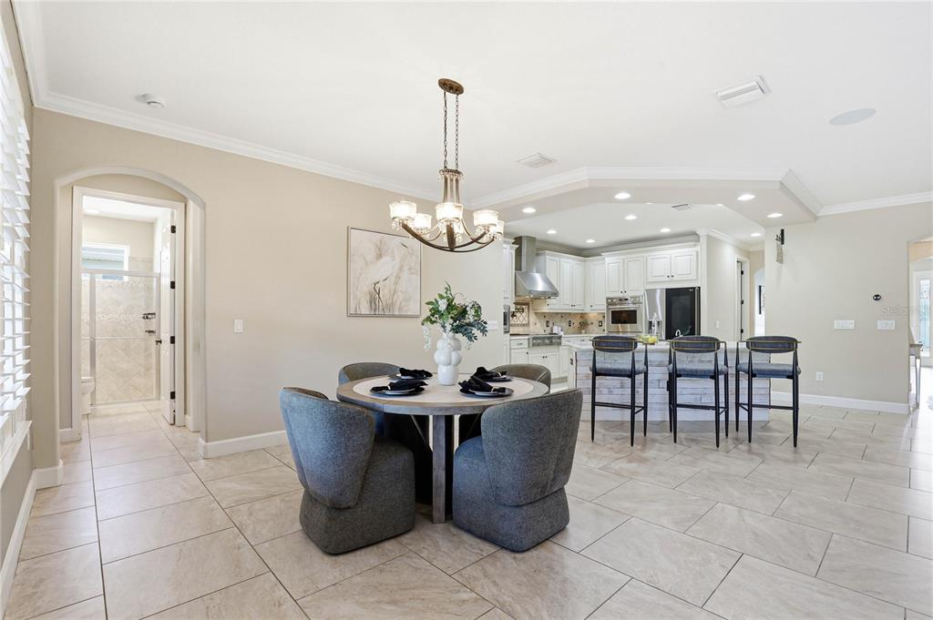 A single-story house exterior features a covered porch, stone pillars, and an American flag — 1737 VIRGINIA WILLOW DRIVE, WESLEY CHAPEL, FL