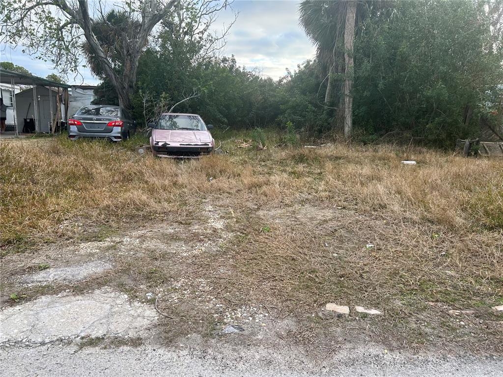 An overgrown vacant lot features two parked cars and a small shed under trees — 6514 ELEANOR DRIVE, PORT RICHEY, FL