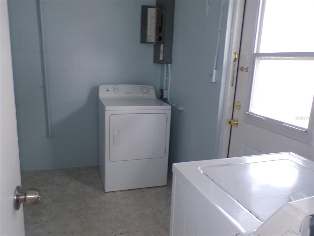 A laundry room with a white dryer, a washing machine, and an electrical panel — 4011 GROBE STREET, NORTH PORT, FL