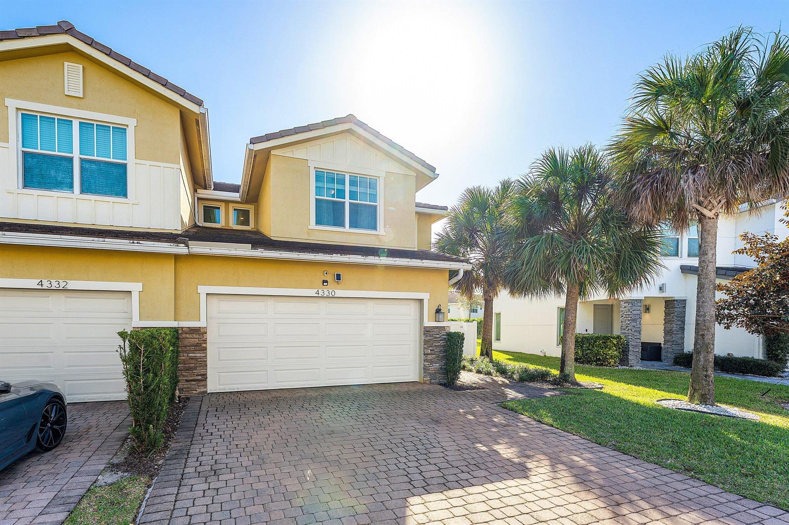 A two-story yellow stucco house with a paved driveway and a palm tree in front — 4330 Lago Drive, Deerfield Beach FL 33064, DEERFIELD BEACH, FL