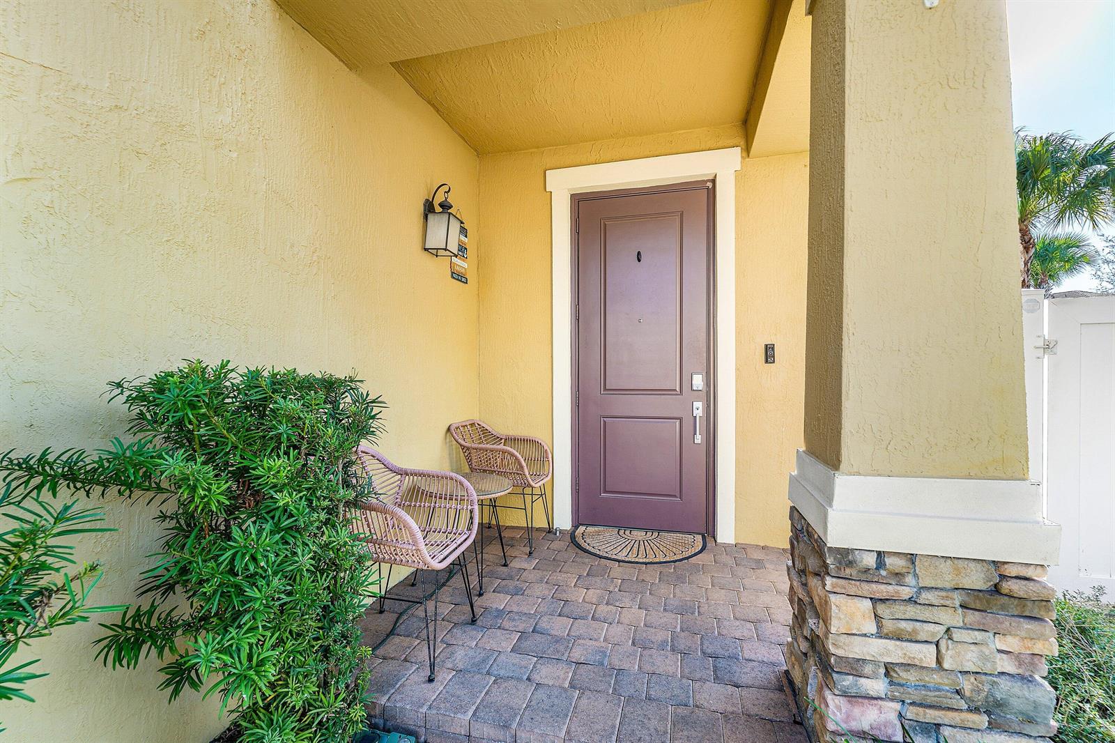 A two-story yellow stucco townhouse features a two-car garage and a paved driveway — 4330 Lago Drive, Deerfield Beach FL 33064, DEERFIELD BEACH, FL