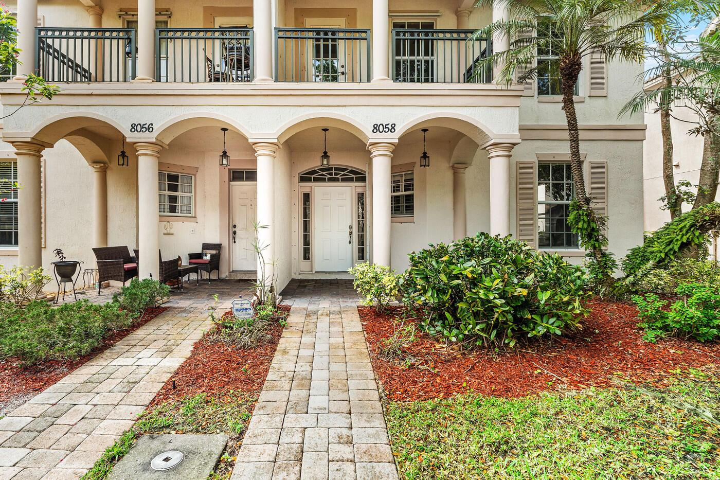 A two-story building exterior features arched entryways, a brick walkway, and a second-floor balcony — 8058 Murano Circle, Palm Beach Gardens FL 33418, PALM BEACH GARDENS, FL