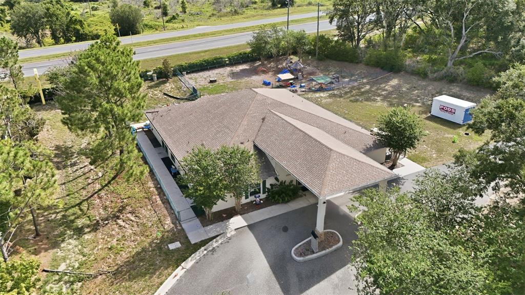 An aerial view shows a single-story building with a covered entrance and a fenced playground — 20540 INDEPENDENCE BOULEVARD, GROVELAND, FL
