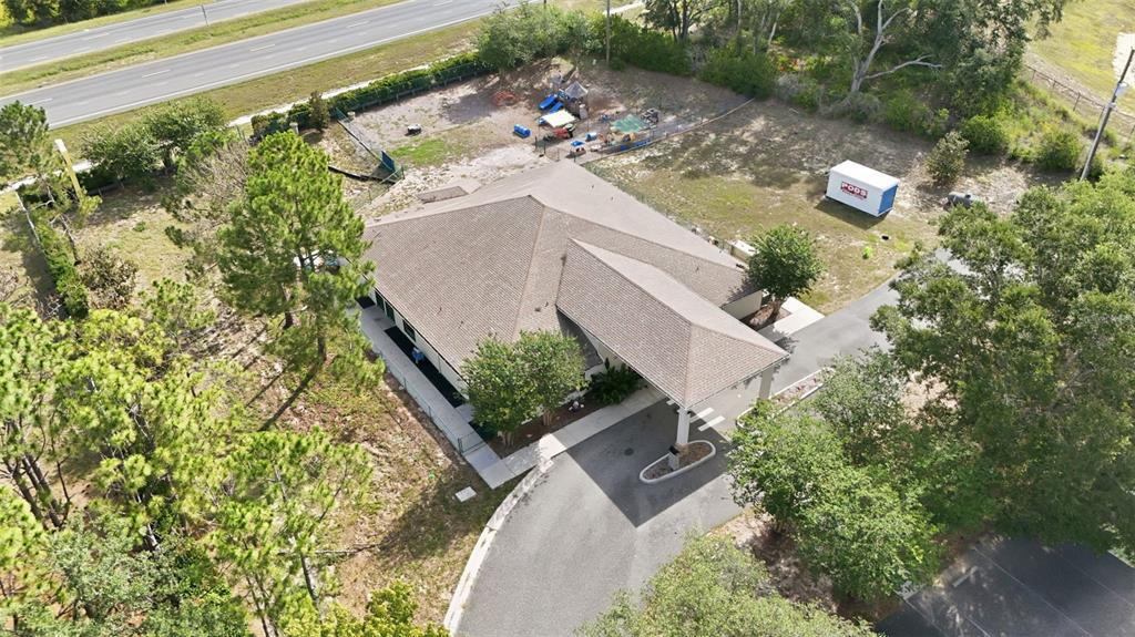 An aerial view shows a building with a covered entrance, playground, and a storage container — 20540 INDEPENDENCE BOULEVARD, GROVELAND, FL