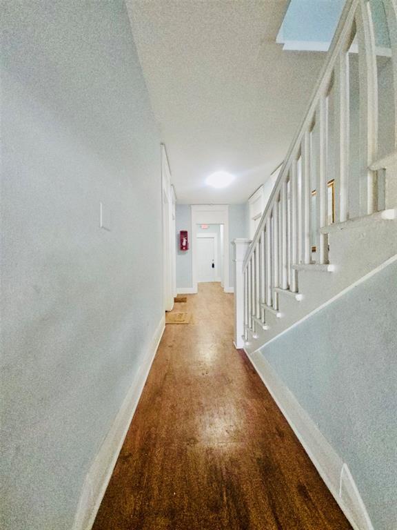 A hallway with wood flooring, light-colored walls, and a staircase with a white railing — 2301 N JEFFERSON STREET, TAMPA, FL