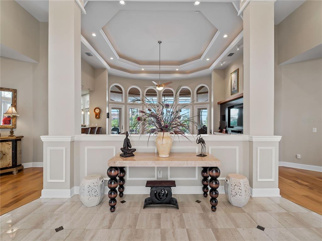 A foyer features a stone console table, decorative stools, and a tray ceiling with recessed lighting — 1443 SURFBIRD COURT, PUNTA GORDA, FL