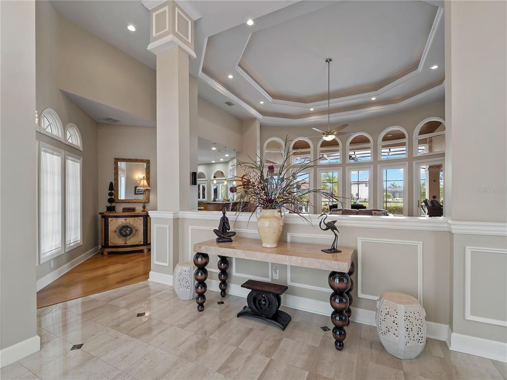 A foyer with marble flooring features a console table and a view into the living room — 1443 SURFBIRD COURT, PUNTA GORDA, FL