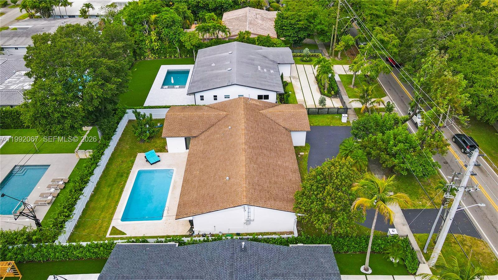 An aerial view shows two adjacent houses with swimming pools and surrounding trees — 1850 NE 199th St, Miami FL 33179, MIAMI, FL