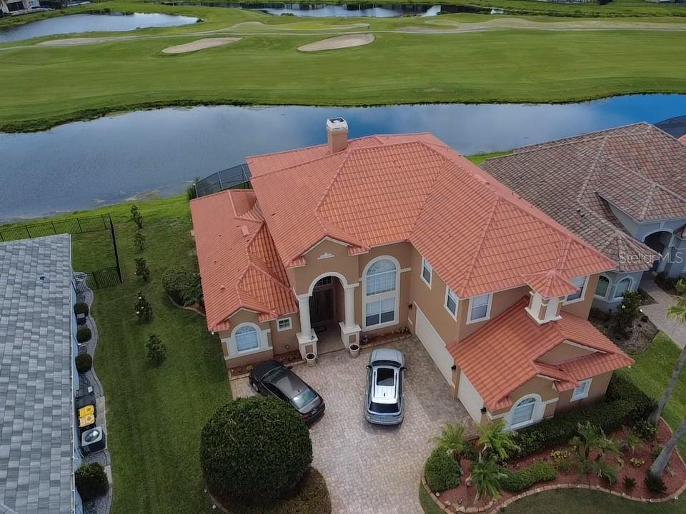 A two-story stucco house with a red tile roof and a paved driveway — 2604 HERITAGE GREEN AVENUE, DAVENPORT, FL