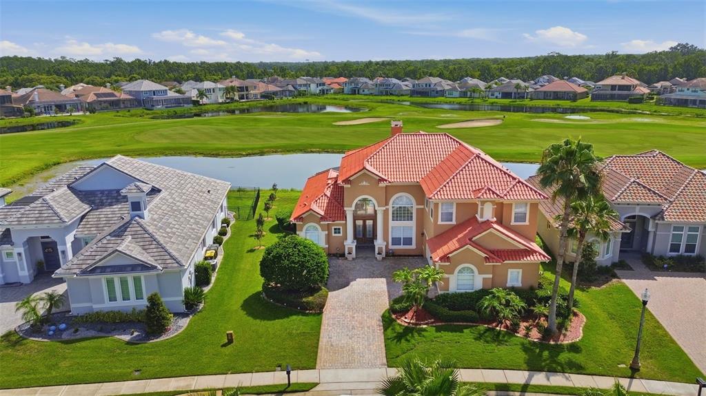 An aerial view of a tan house with a red tile roof overlooking a golf course — 2604 HERITAGE GREEN AVENUE, DAVENPORT, FL