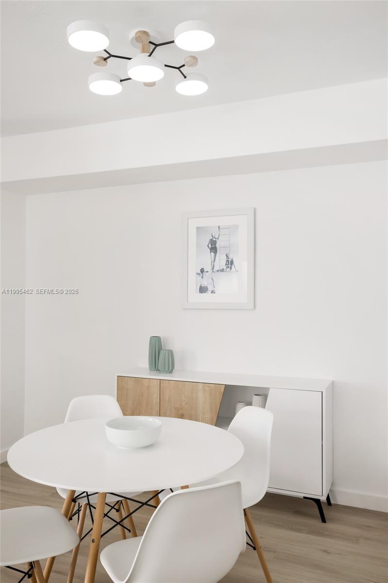A dining area features a white round table, four chairs, and a modern light fixture — 9881 E Bay Harbor Dr # 504, Bay Harbor Islands FL 33154, BAY HARBOR ISLANDS, FL