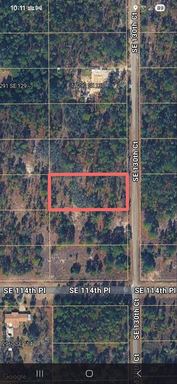 This is an aerial map view showing a rectangular plot of land highlighted in red — 00 SE 130TH CT, DUNNELLON, FL