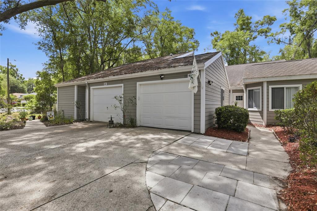 The exterior of a gray house features a two-car garage and a paved walkway — 829 NW 124TH DRIVE, NEWBERRY, FL