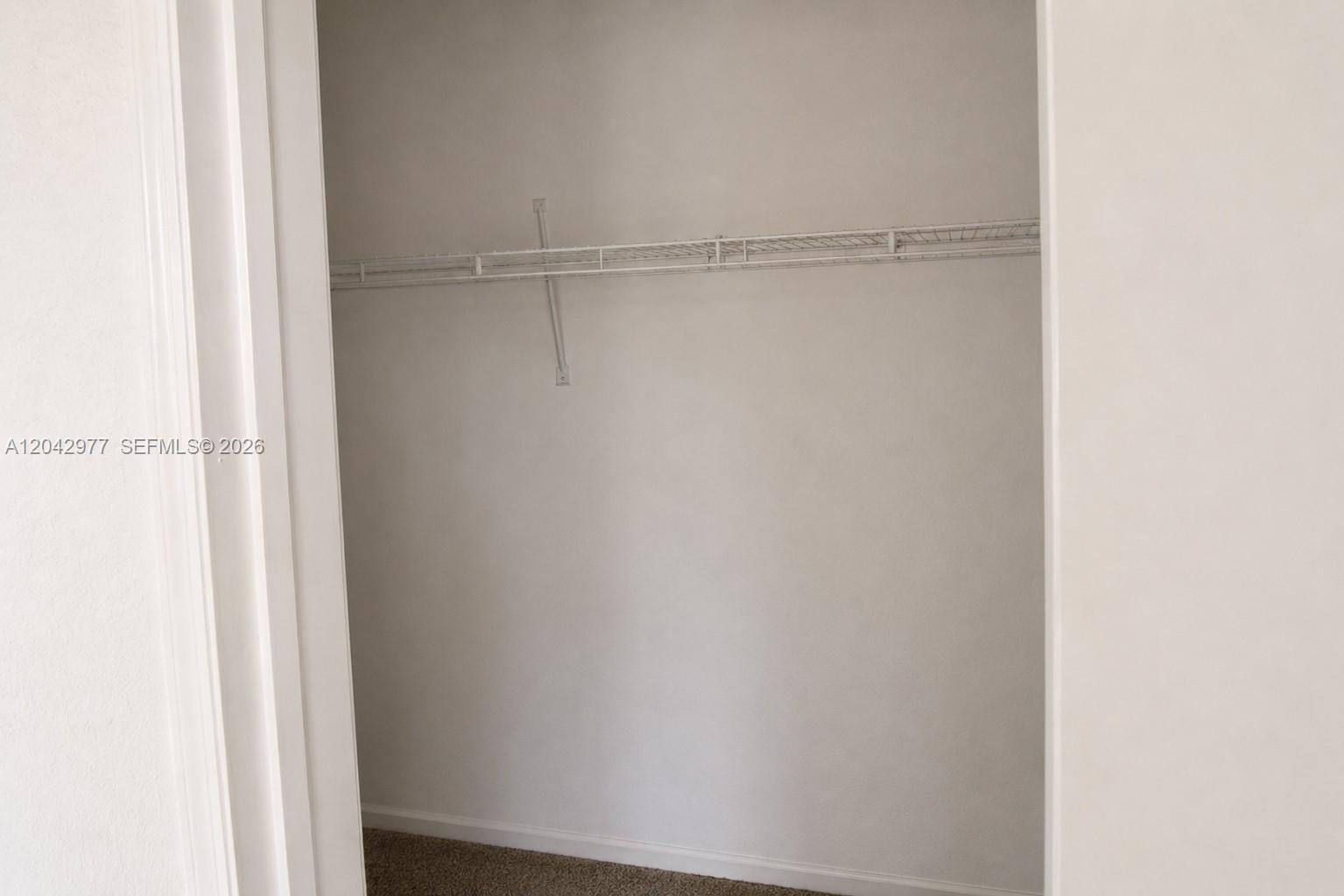 A small closet features a single white wire shelf and carpeted flooring — 420 NW 84th Ter # 420, Miami FL 33150, MIAMI, FL