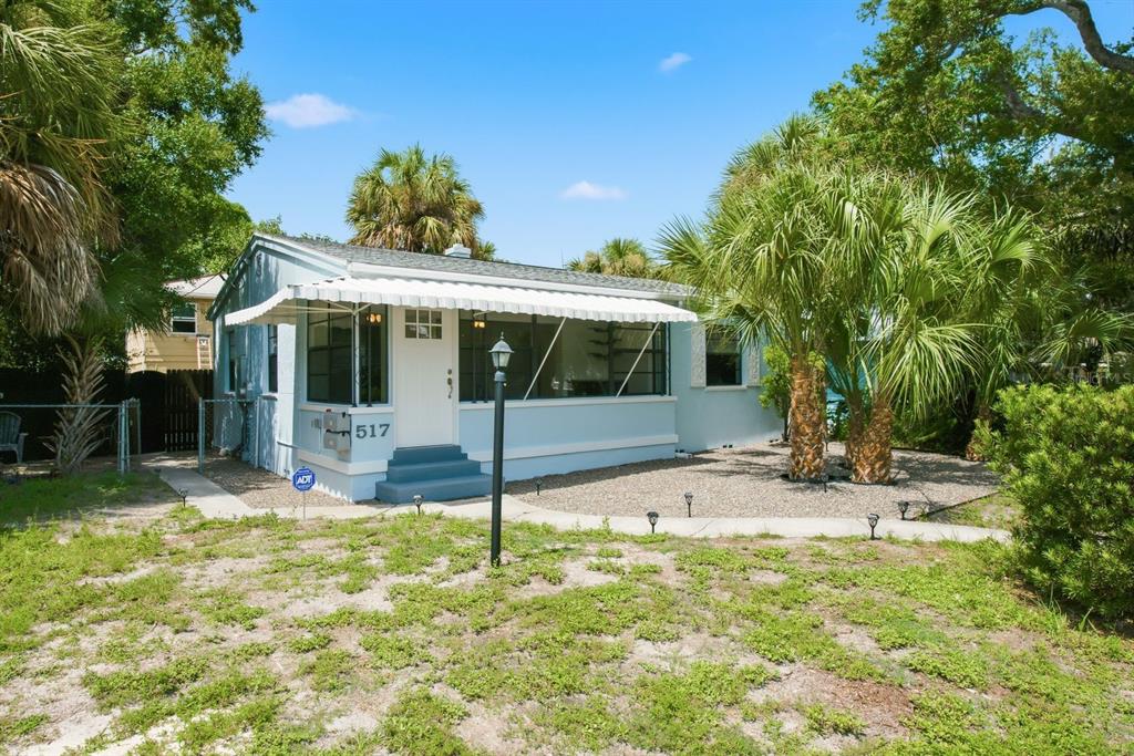 A light blue single-story house with a white awning over the front porch and palm trees — 517 41ST AVENUE S, ST PETERSBURG, FL