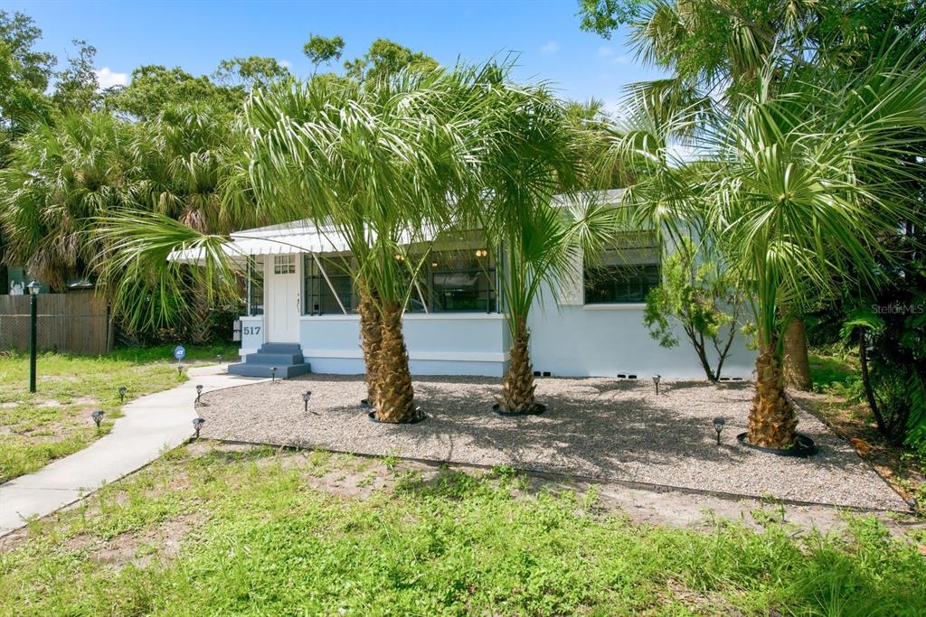 A light blue single-story house features a gravel front yard with three palm trees — 517 41ST AVENUE S, ST PETERSBURG, FL