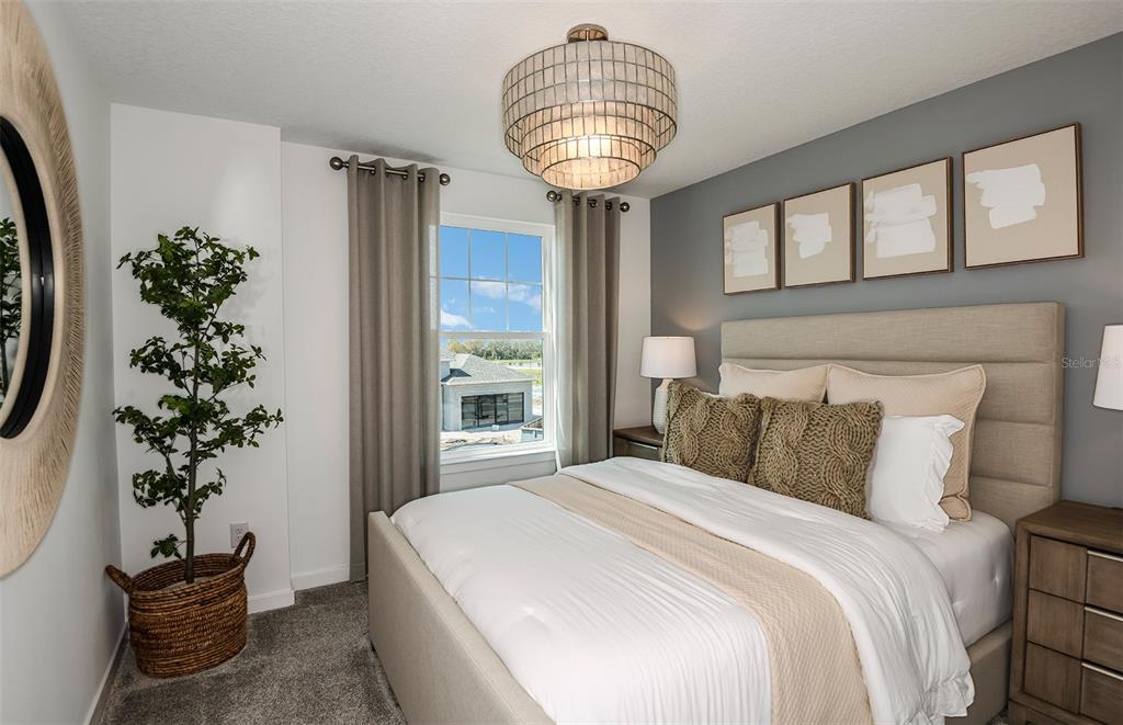 A bedroom features a bed with a beige headboard, gray accent wall, and a drum chandelier — 1444 HAMILTON WAY, LAKE ALFRED, FL