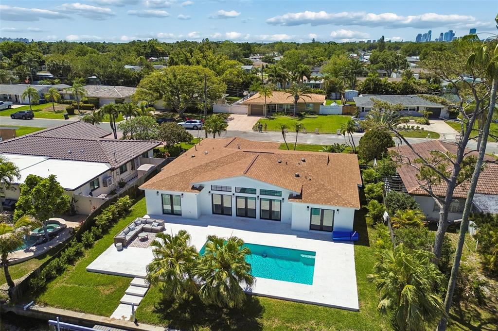 An aerial view of a white house with a brown roof, swimming pool, and patio — 797 45TH AVENUE NE, ST PETERSBURG, FL