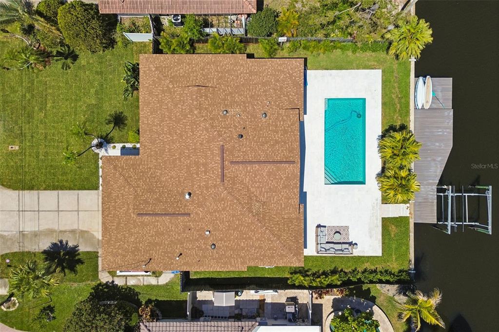 An aerial view shows a house with a brown roof, a pool, and a boat dock — 797 45TH AVENUE NE, ST PETERSBURG, FL