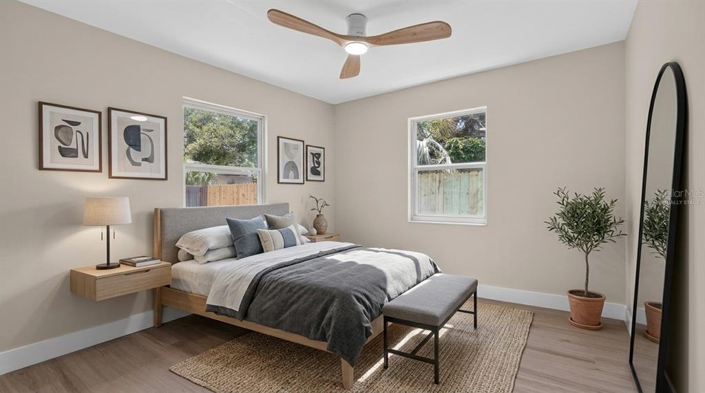 A bedroom with a bed, ceiling fan, two windows, and a full-length floor mirror — 2960 EMERSON AVENUE S, ST PETERSBURG, FL
