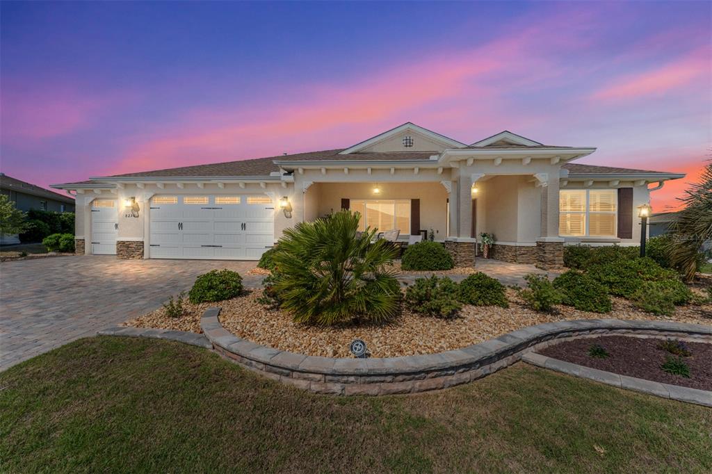 A single-story house with a stone-accented facade, a three-car garage, and a landscaped front yard — 8250 SW 93RD TERRACE, OCALA, FL