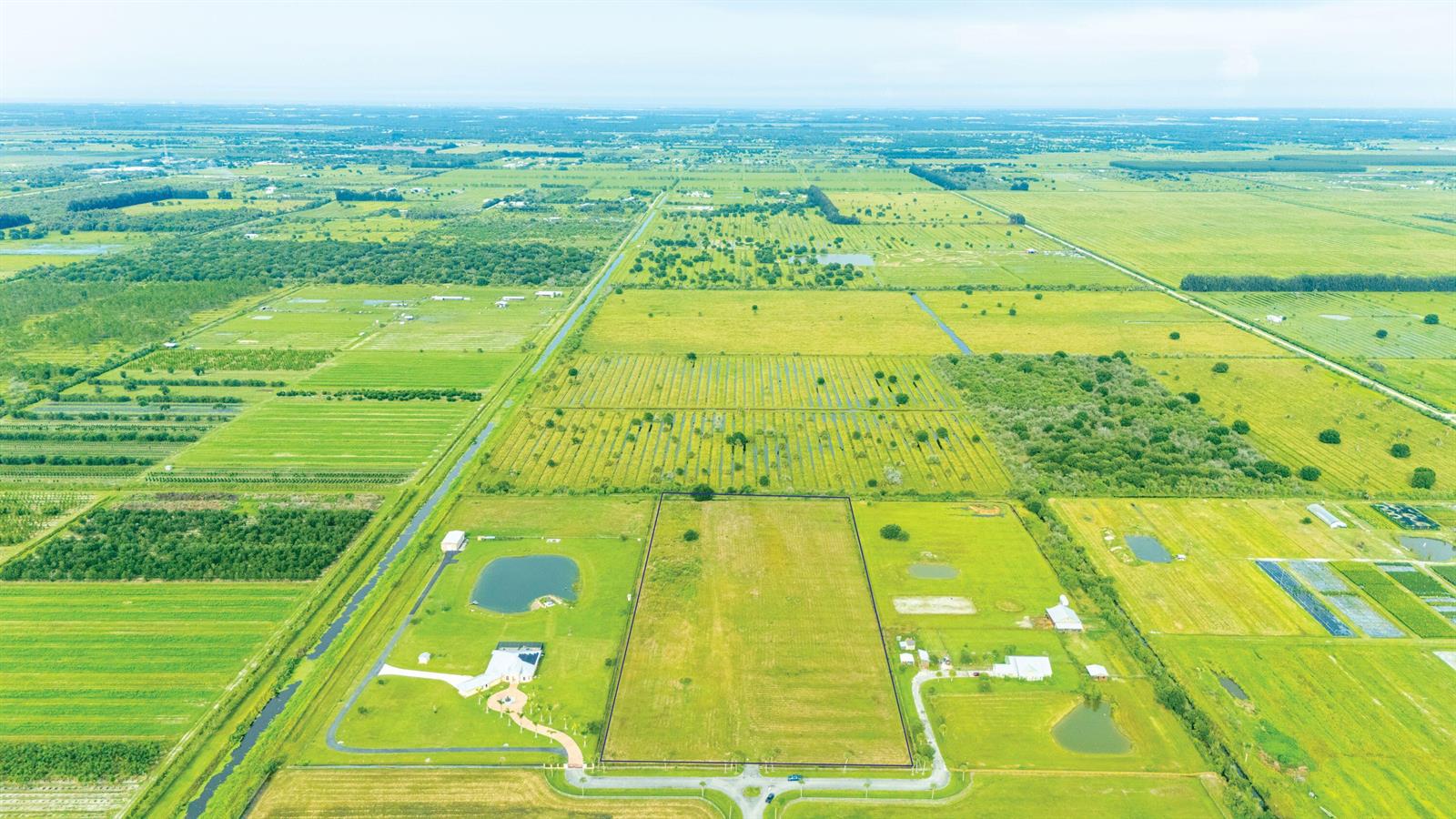 An aerial view shows a large, fenced rectangular plot of land with surrounding rural fields — 4 Sneed Road, Fort Pierce FL 34945, FORT PIERCE, FL