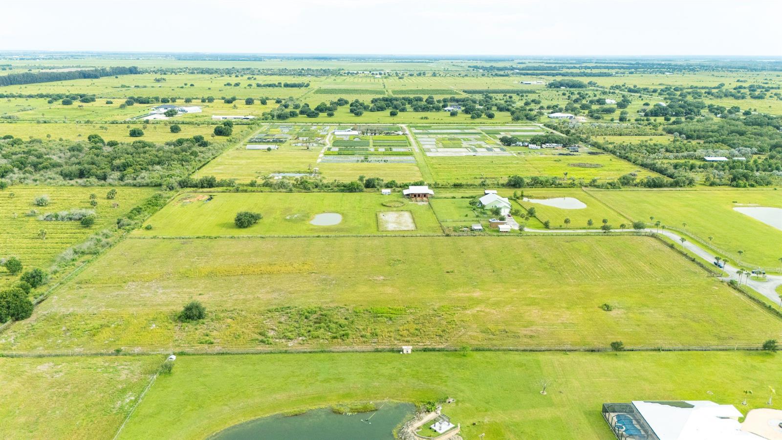 An aerial view shows a large, fenced rural property with open fields, a house, and ponds — 4 Sneed Road, Fort Pierce FL 34945, FORT PIERCE, FL