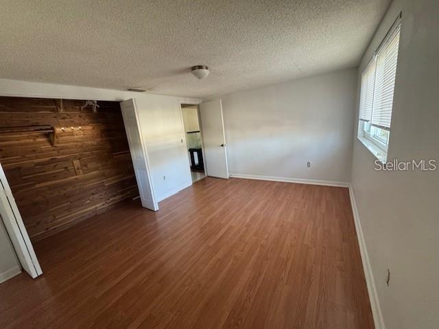 A bedroom with wood-look flooring, a cedar-paneled closet, and a window with blinds — 7235 REDBUD COURT, NEW PORT RICHEY, FL