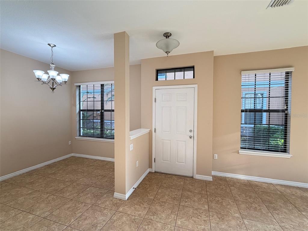 A tiled dining area and entryway feature a white front door and two large windows — 5722 KINGLETHILL DRIVE, LITHIA, FL
