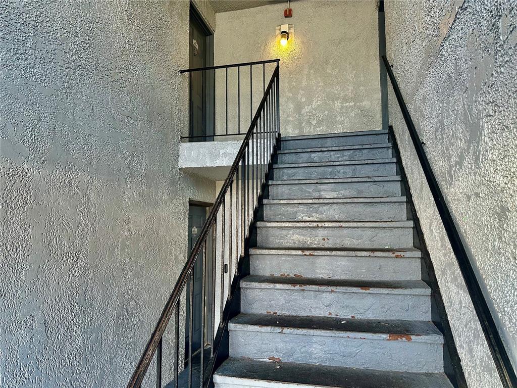 An outdoor concrete staircase leads to two apartment doors with black metal railings — 4805 S TEXAS AVENUE UNIT 4805C, ORLANDO, FL