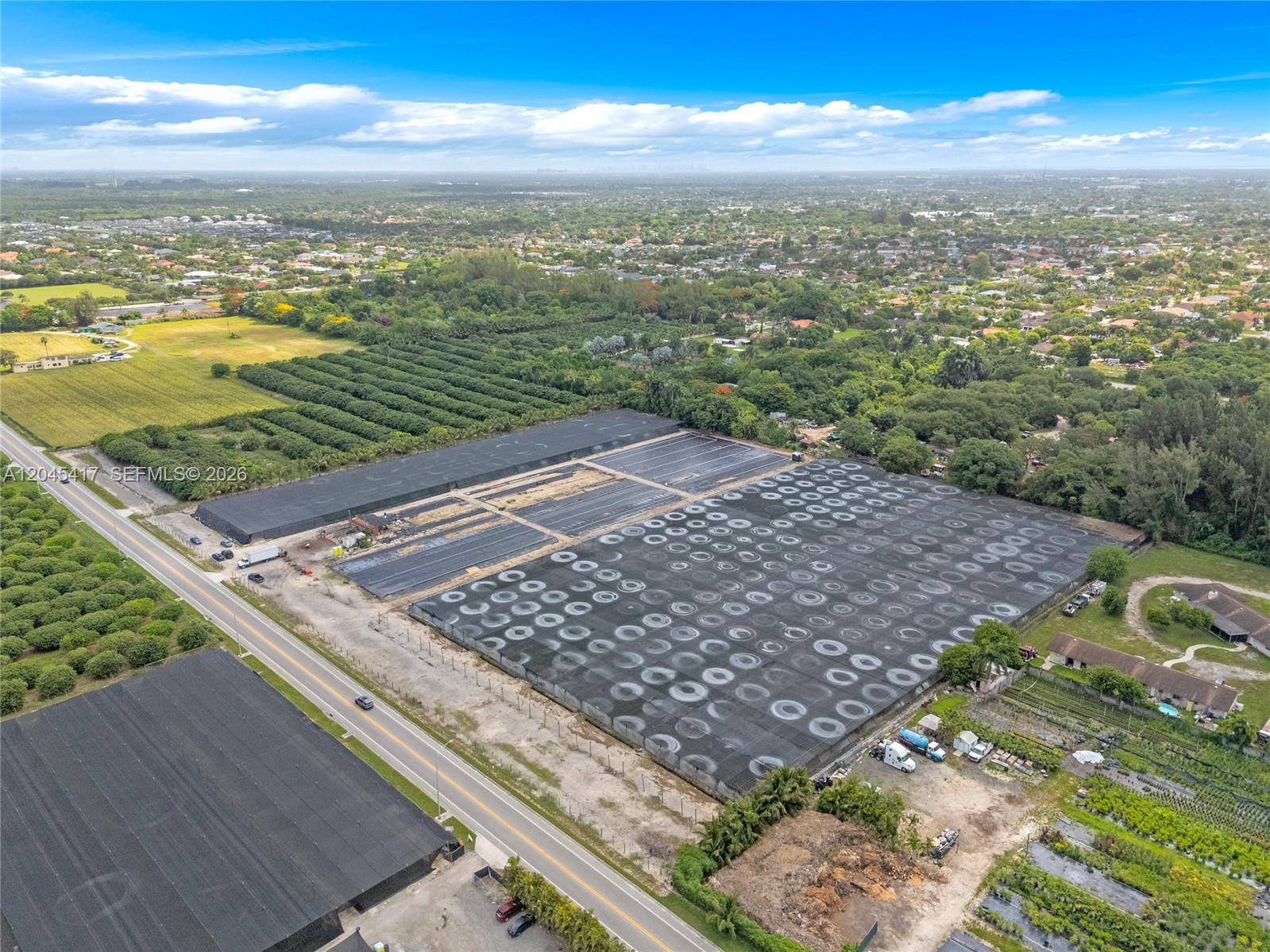 An aerial view shows a large agricultural property with shade houses and rows of crops — 20401 Sw 137th Ave, Miami FL 33177, MIAMI, FL