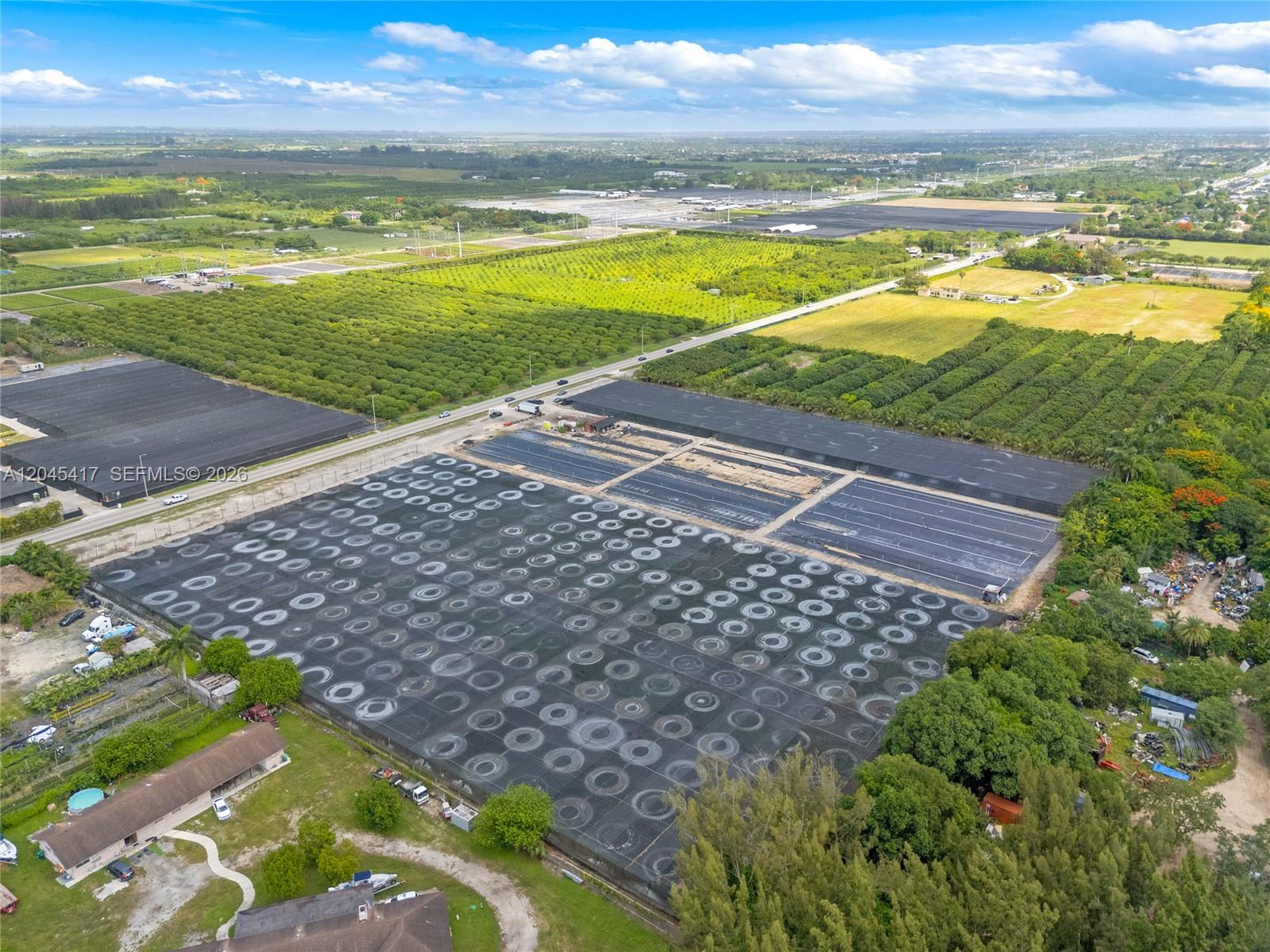 An aerial view shows a large agricultural property with rows of potted plants under netting — 20401 Sw 137th Ave, Miami FL 33177, MIAMI, FL