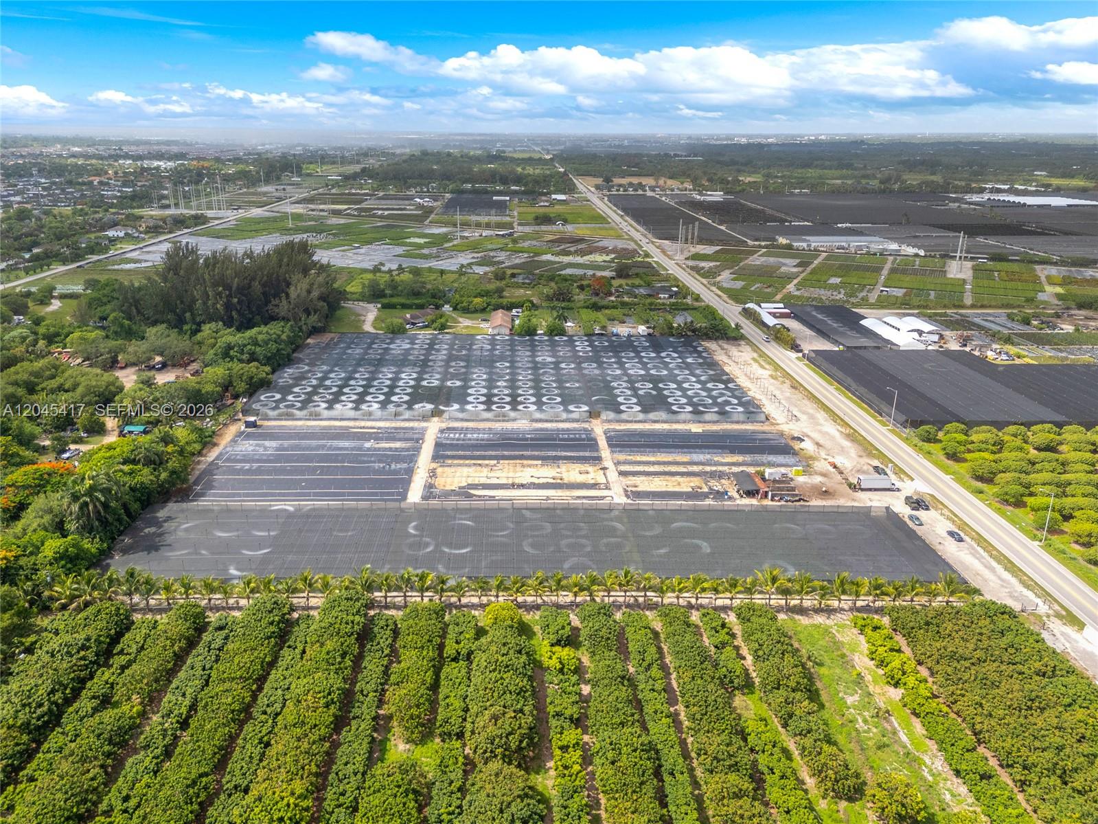 An aerial view shows a large agricultural property with greenhouses, shade structures, and orchard rows — 20401 Sw 137th Ave, Miami FL 33177, MIAMI, FL