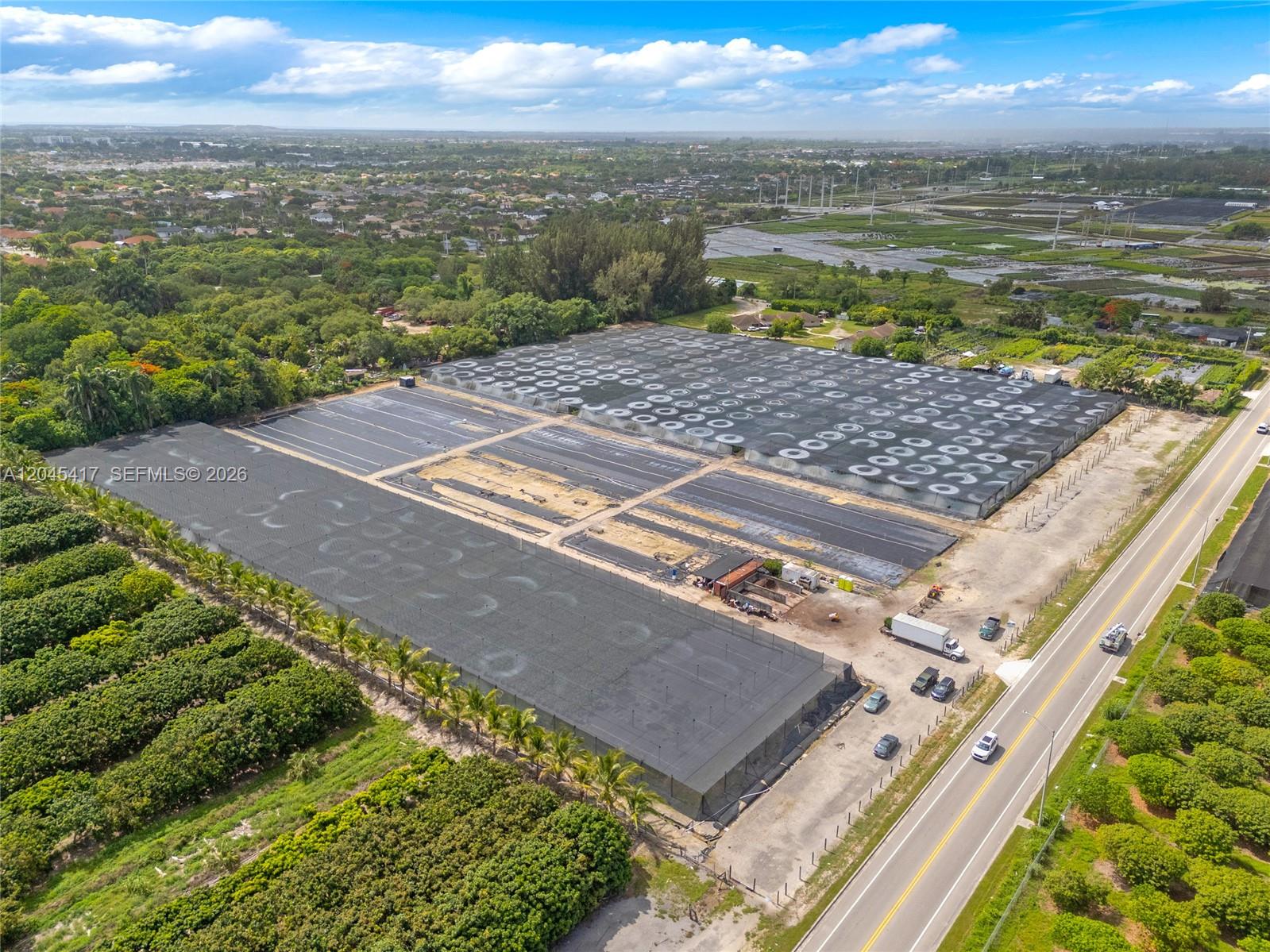 An aerial view shows a large agricultural property with expansive shade structures and greenhouses — 20401 Sw 137th Ave, Miami FL 33177, MIAMI, FL