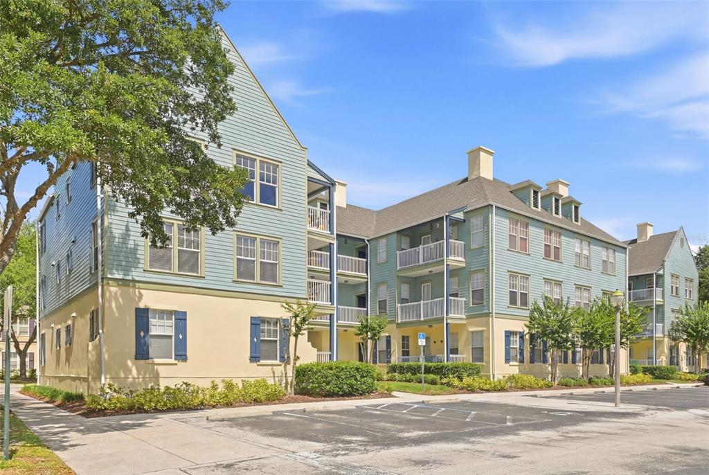 A multi-story apartment building with blue siding, tan stucco, and balconies under a blue sky — 611 CAMPUS STREET UNIT 280, CELEBRATION, FL