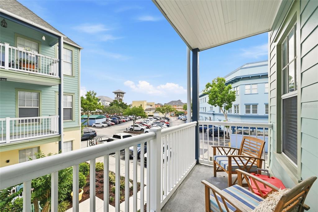 A balcony with white railings overlooks a parking lot between two multi-story apartment buildings — 611 CAMPUS STREET UNIT 280, CELEBRATION, FL