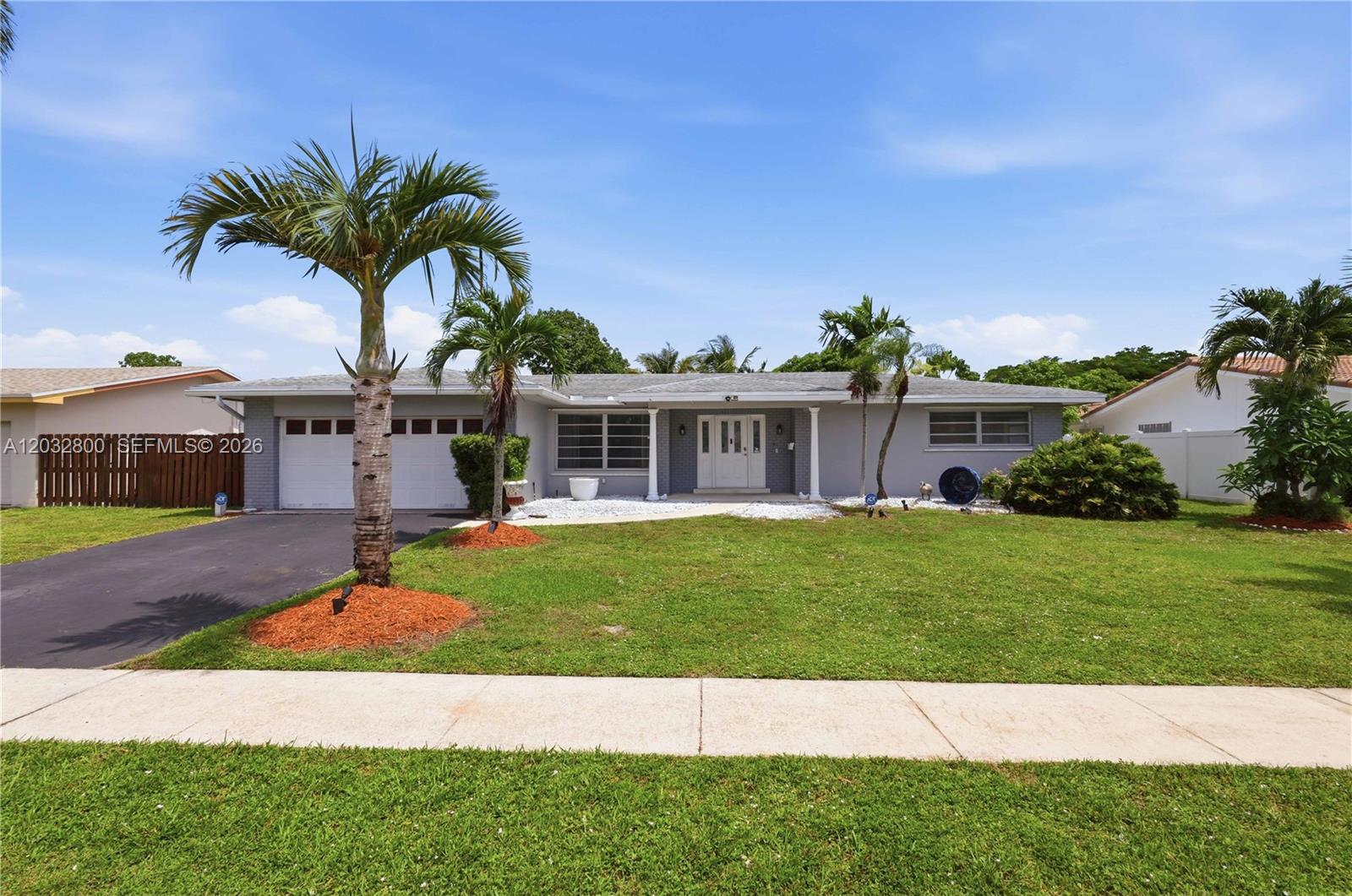 A single-story gray house with a two-car garage and palm trees in the front yard — 7421 NW 14th St, Plantation FL 33313, PLANTATION, FL