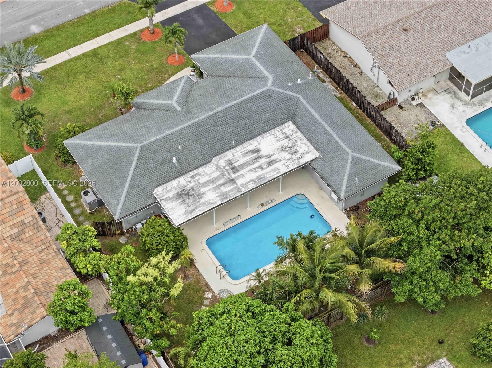 An aerial view shows a house with a gray roof, a pool, and a patio — 7421 NW 14th St, Plantation FL 33313, PLANTATION, FL