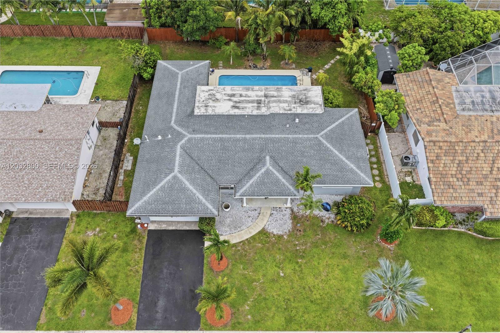 An aerial view shows a house with a gray shingled roof and a backyard pool — 7421 NW 14th St, Plantation FL 33313, PLANTATION, FL