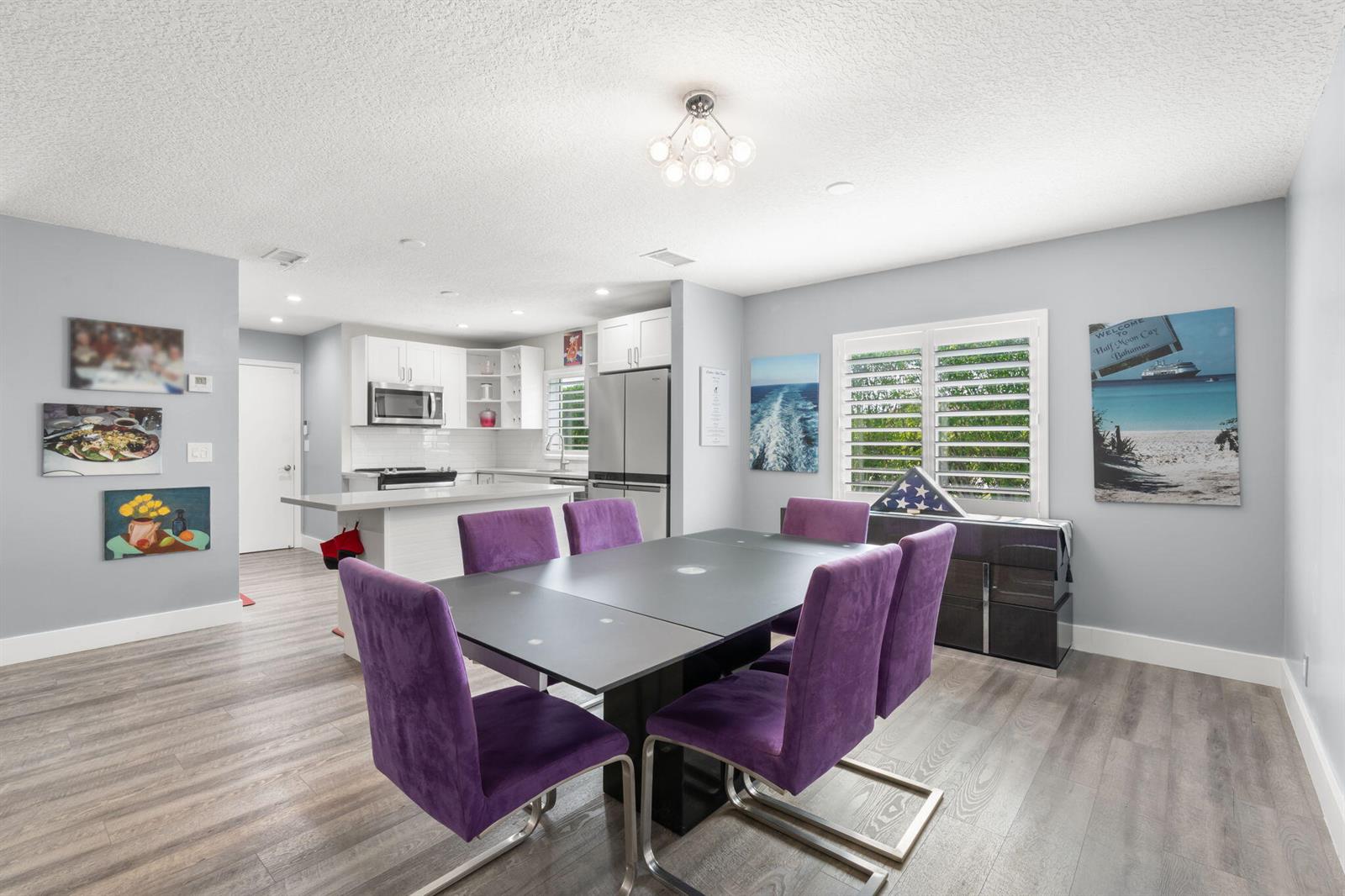 A dining area with a dark table and purple chairs adjacent to a white kitchen — 13491 Via Vesta, Delray Beach FL 33484, DELRAY BEACH, FL