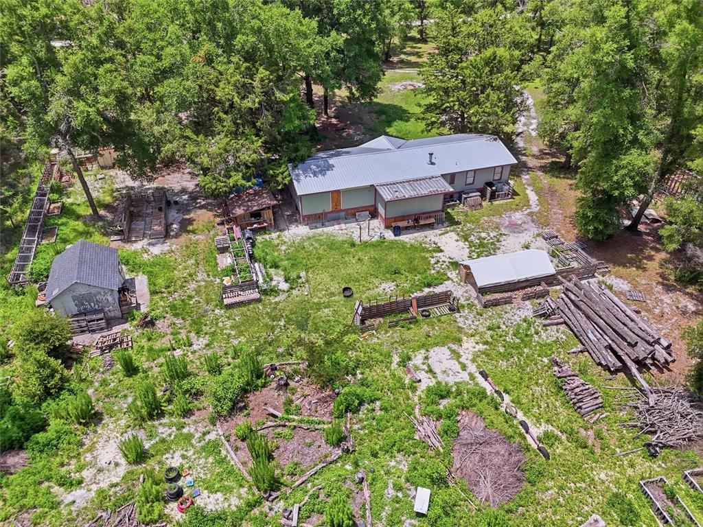 An aerial view shows a house with a metal roof surrounded by trees and outbuildings — 12725 212TH TERRACE, O'BRIEN, FL